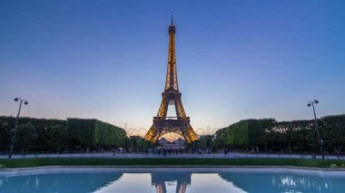 Eyfel Kulesi gün gece timelapse ve Paris, Fransa akşamları çimlerde oturan insanlar