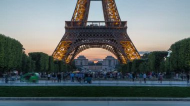 Eyfel Kulesi gün gece timelapse ve Paris, Fransa akşamları çimlerde oturan insanlar