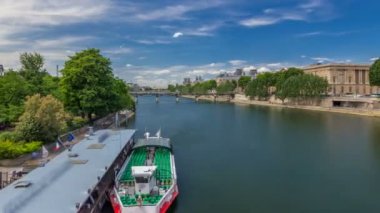 Turistik tekne Pont des Arts 'ın aşağısından geçiyor ve Paris' te Seine Nehri 'ndeki tekne istasyonunda duruyor..