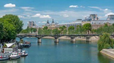 Turistik tekne, Paris 'teki Seine Nehri' ndeki tekne istasyonunda Pont des Arts 'ın altından geçiyor..