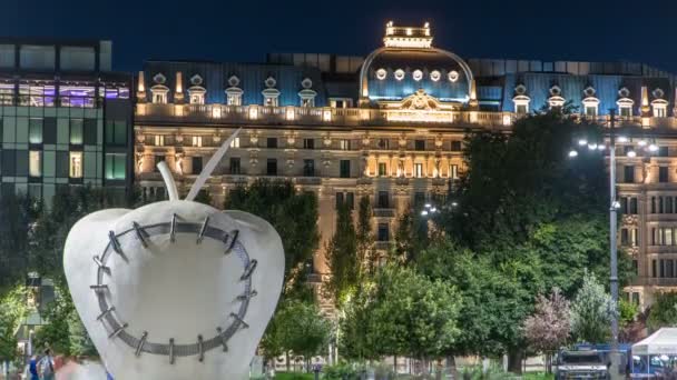 На Монументальна скульптура реінтегровано яблуко перед Milans Центральний залізничний вокзал ніч timelapse. — стокове відео