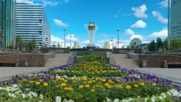 Bloemen op Nurzhol Boulevard met Baiterek op achtergrond timelapse hyperlapse — Stockvideo