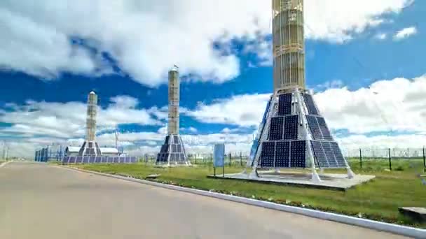 Torres de paneles solares en planta solar con torre de alto voltaje en hiperlapso de tiempo de fondo — Vídeos de Stock