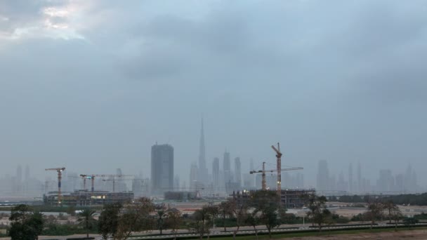 Skyline de la torre de las grúas de la construcción con los rascacielos en el fondo en el timelapse del día a la noche del Oriente Medio, Dubai — Vídeos de Stock