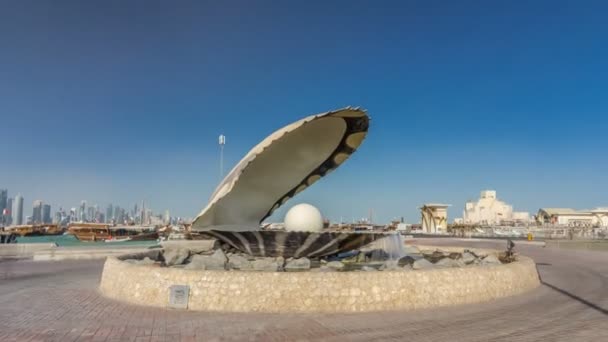 Фонтан із зображенням устриці з гігантською перлиною всередині гіперлапсу таймелапса з хмарочосом Доха позаду нього. — стокове відео