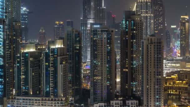 Timelapse du paysage urbain aérien la nuit avec une architecture moderne éclairée dans le centre-ville de Dubaï, Émirats arabes unis . — Video