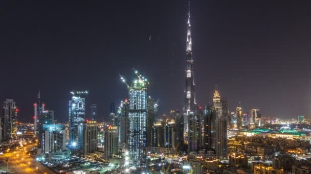 Cronologia aerea del paesaggio urbano di notte con architettura moderna illuminata nel centro di Dubai, Emirati Arabi Uniti . — Video Stock