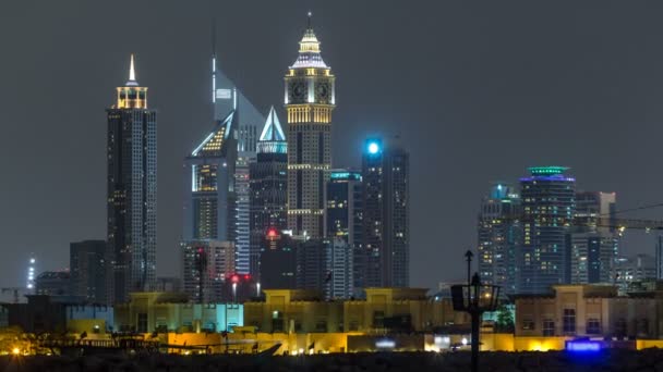 Esboço moderno da cidade de Dubai timelapse à noite com arranha-céus iluminados sobre a superfície da água — Vídeo de Stock