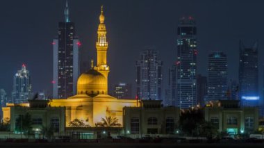 Modern Dubai şehir manzarası timelapse Rashid Al hadis Camii ile su yüzeyi üzerinde ışıklandırılmış gökdelenler ile gece