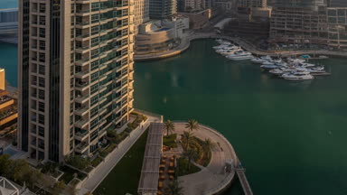 Modern gökdelenler gündoğumu ışıklar timelapse Dubai, Birleşik Arap Emirlikleri Dubai Marina içinde parlayan görünümünü.