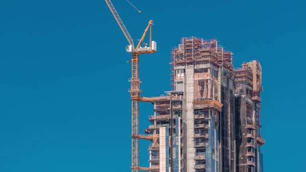 Vue aérienne d'un gratte-ciel en construction avec d'énormes grues timelapse à Dubaï . — Video