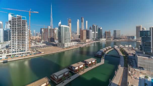 Rascacielos cerca de canal en Dubai con cielo azul timelapse aéreo — Vídeos de Stock