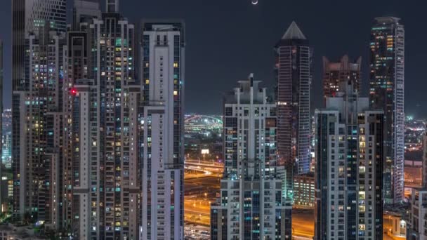 Moderno complejo residencial y de oficinas con muchas torres de noche aérea timelapse en Business Bay, Dubai, Emiratos Árabes Unidos . — Vídeos de Stock