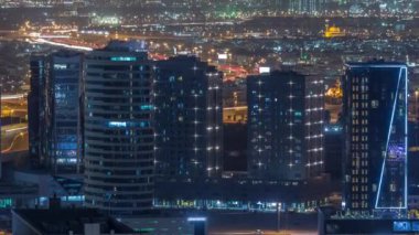 Dubai 'deki otoyolların yakınındaki yüksek gökdelenlerin parlak ışıklarının görüntüsü, Birleşik Arap Emirlikleri Hava Saati