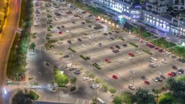Gece vakti Dubai 'deki aydınlık park alanındaki bir çok arabanın görüntüsü.