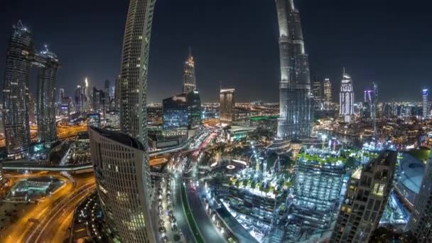 Panoramisch uitzicht op de skyline van Dubai centrum met een winkelcentrum, fonteinen en wolkenkrabbers lucht nacht timelapse — Stockvideo