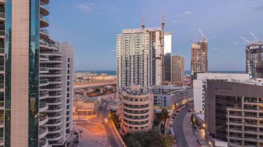 Dubai Marina gökdelenleri ve gezinti güvertesi gece gündüz saatleri, Dubai, Birleşik Arap Emirlikleri