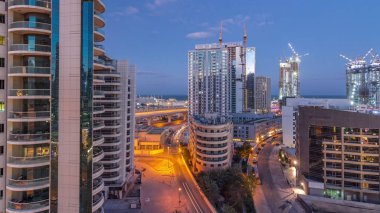 Dubai Marina gökdelenleri ve gezinti güvertesi gece gündüz saatleri, Dubai, Birleşik Arap Emirlikleri