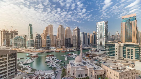 Yates en Dubai Marina flanqueado por la mezquita Al Rahim y torres residenciales y rascacielos timelapse aéreo . — Foto de Stock