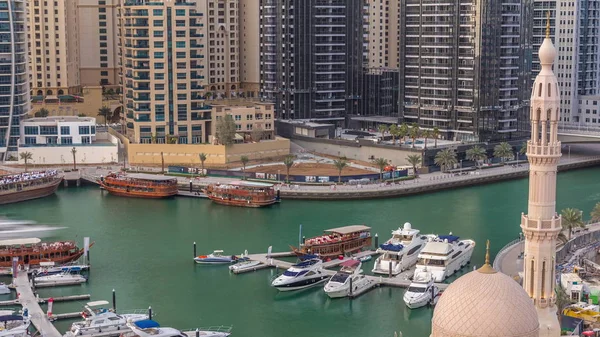 Yachts in Dubai Marina flanked by the Al Rahim Mosque and residential towers and skyscrapers aerial timelapse. — Stock Photo, Image
