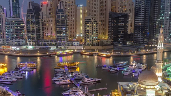 Yacht a Dubai Marina affiancato dalla Moschea Al Rahim e torri residenziali e grattacieli aereo giorno a notte timelapse . — Foto Stock