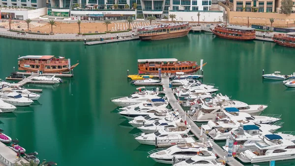 Люксовые яхты припарковались на пирсе в бухте Дубай Марина с видом на город — стоковое фото