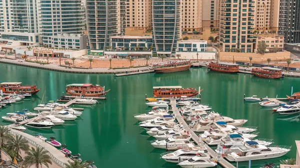 Luxury yachts parked on the pier in Dubai Marina bay with city aerial view timelapse — Stock Photo, Image