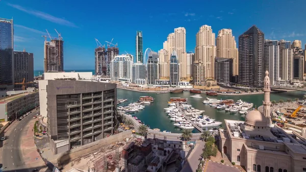 Yates en Dubai Marina flanqueado por la mezquita Al Rahim y torres residenciales y rascacielos timelapse aéreo . —  Fotos de Stock