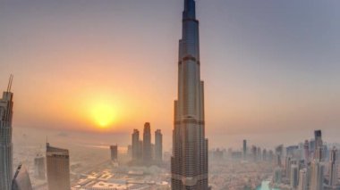 Alışveriş merkezi, çeşmeler ve Burj Khalifa hava sabah timelapse ile gün doğumu sırasında Dubai şehir merkezinde Paniramik siluet görünümü