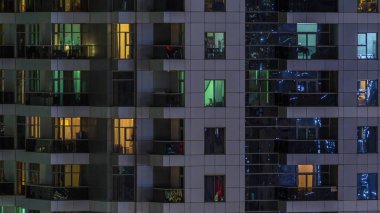 Geceleri apartmanda insanların oturduğu parlak pencereler..