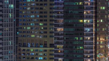 Geceleri apartmanda insanların oturduğu parlak pencereler..