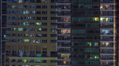 Geceleri apartmanda insanların oturduğu parlak pencereler..