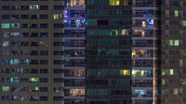 Geceleri apartmanda insanların oturduğu parlak pencereler..