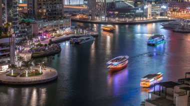 Dubai Marina Limanı 'ndaki rıhtım güvertesi gece uçuşları. Dubai, Birleşik Arap Emirlikleri