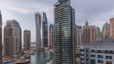 Dubai Marina yerleşim yerlerinin ve ofis gökdelenlerinin havadan görüntüsü. Rıhtıma bakan gündüz ve gece saatleri var.