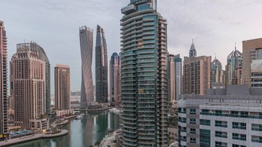 Dubai Marina konutlarının ve ofis gökdelenlerinin havadan görüntüsü. Gece gündüz deniz manzaralı.