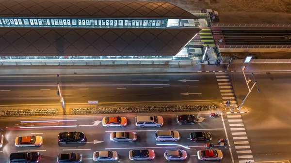 Korsning med bilar och spårvagnshållplats med järnvägsantenn utsikt från ovan natt timelapse i Dubai Marina — Stockfoto