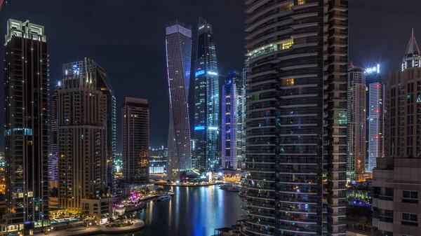 Вид с воздуха на жилые и офисные небоскребы Dubai Marina с ночной набережной
