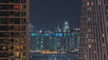 Hava görüntüsü Dubai marina gökdelenleri inşaat alanı ve Palm Jumeirah Adası 'nın arka planında gece zaman çizelgesi.
