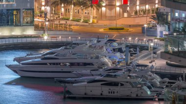 Dubai Marina Limanı 'ndaki rıhtım güvertesi gece uçuşları. Dubai, Birleşik Arap Emirlikleri