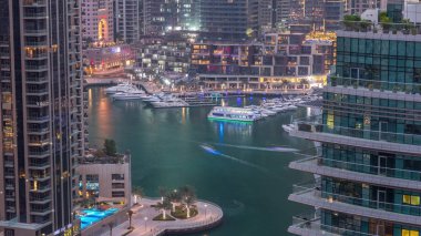 Dubai Marina yerleşim yerlerinin ve ofis gökdelenlerinin havadan görüntüsü. Rıhtıma bakan gündüz ve gece saatleri var.
