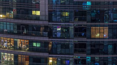 Geceleri apartmanda insanların oturduğu parlak pencereler..
