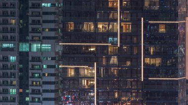 Geceleri apartmanda insanların oturduğu parlak pencereler..