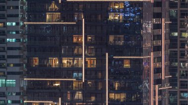 Geceleri apartmanda insanların oturduğu parlak pencereler..