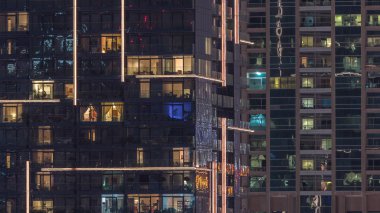 Geceleri apartmanda insanların oturduğu parlak pencereler..