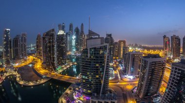 Dubai Marina konutlarının ve ofis gökdelenlerinin havadan görüntüsü. Gece gündüz deniz manzaralı.