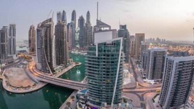 Dubai Marina konutlarının ve ofis gökdelenlerinin havadan görüntüsü. Gece gündüz deniz manzaralı.