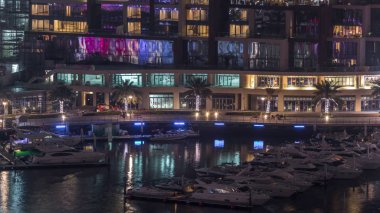 Dubai Marina Limanı 'ndaki rıhtım güvertesi gece uçuşları. Dubai, Birleşik Arap Emirlikleri
