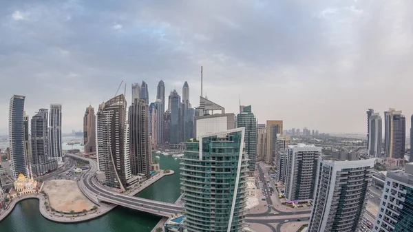Vista aérea dos arranha-céus residenciais e de escritório da Marina do Dubai com a timelapse do dia à noite à beira-mar — Fotografia de Stock