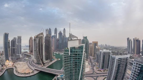 Aerial view of Dubai Marina residential and office skyscrapers with waterfront day to night timelapse — Stock Photo, Image